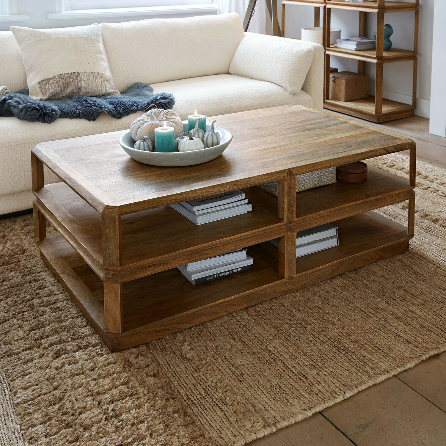 Mesa de centro Inverly Mesa de centro de madera natural con estantes, decorada con velas y calabazas en salón acogedor