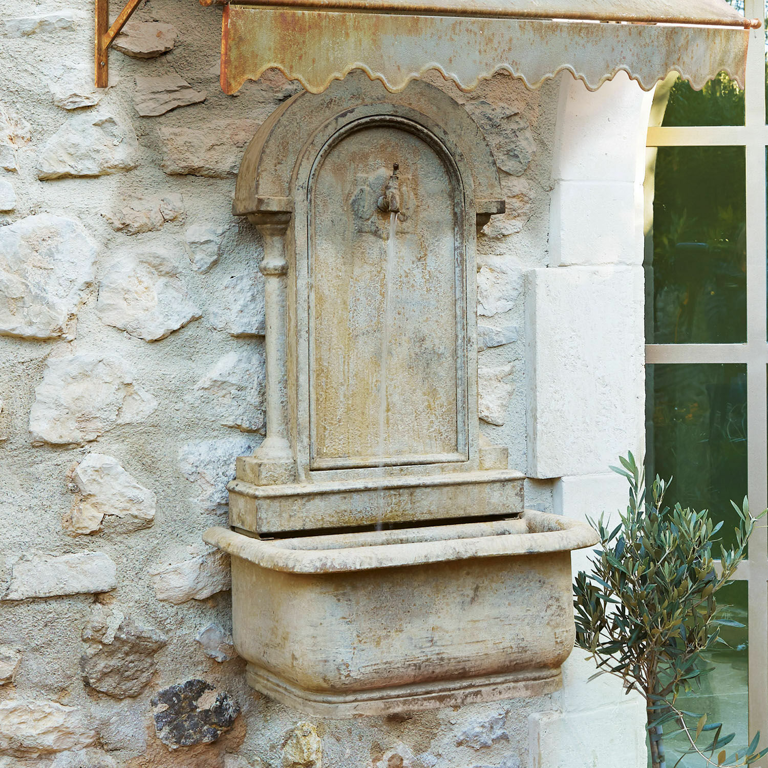 Fuente mural Ivera Fuente de pared de piedra beige con cubierta metálica oxidada y chorro de agua decorativo