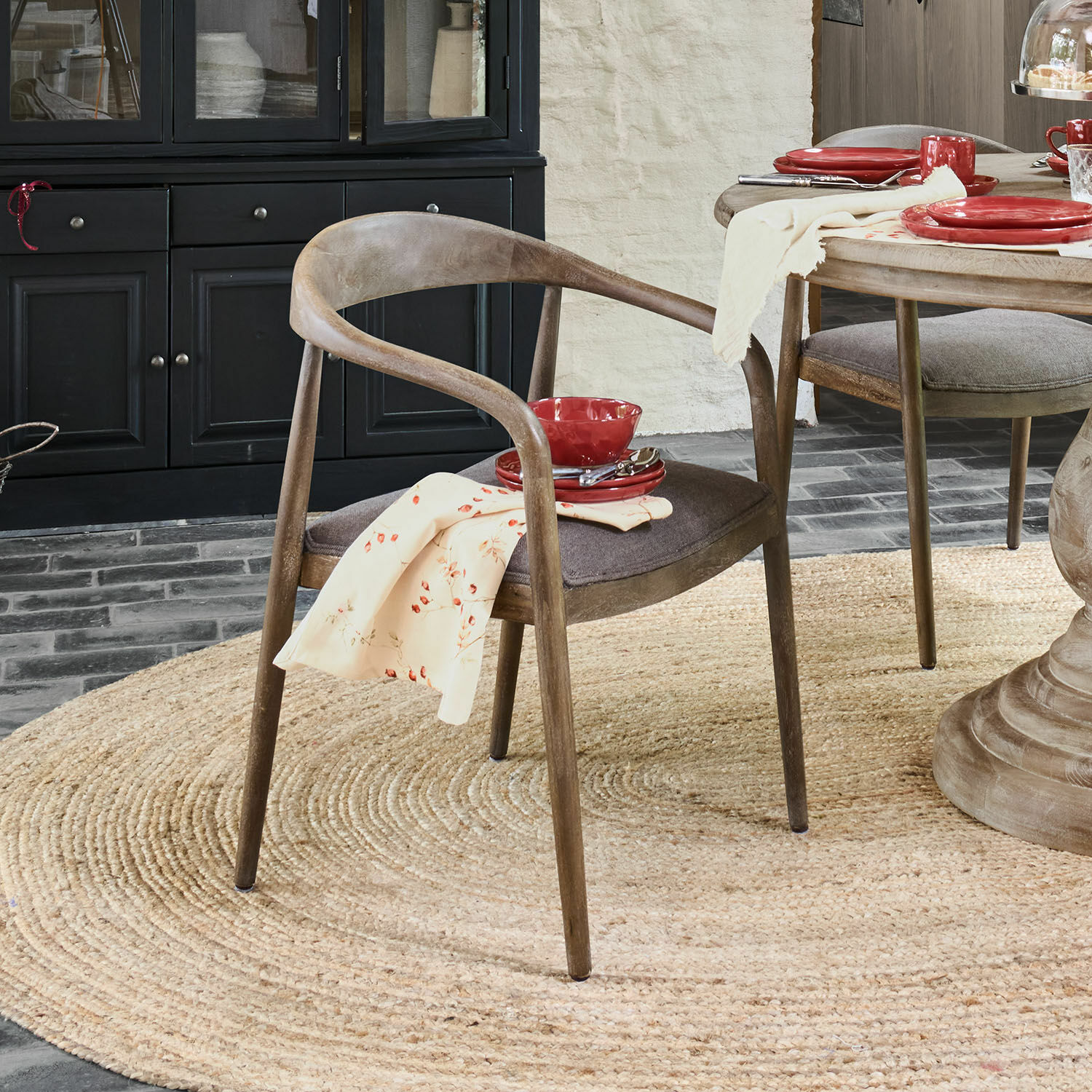 Silla Lucarno Silla de comedor de madera natural con asiento gris y vajilla roja sobre mesa de madera clara