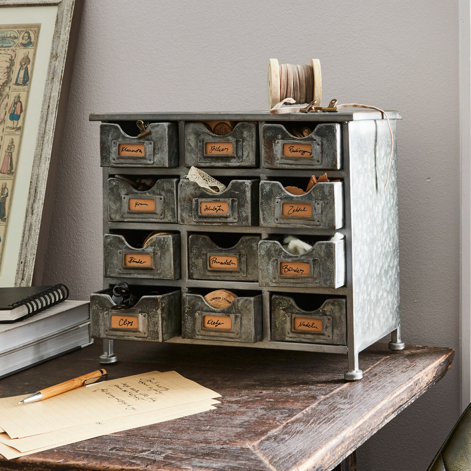 Organizador Serena Mueble metálico gris con 12 cajones para organizar pequeños objetos y accesorios de escritorio.