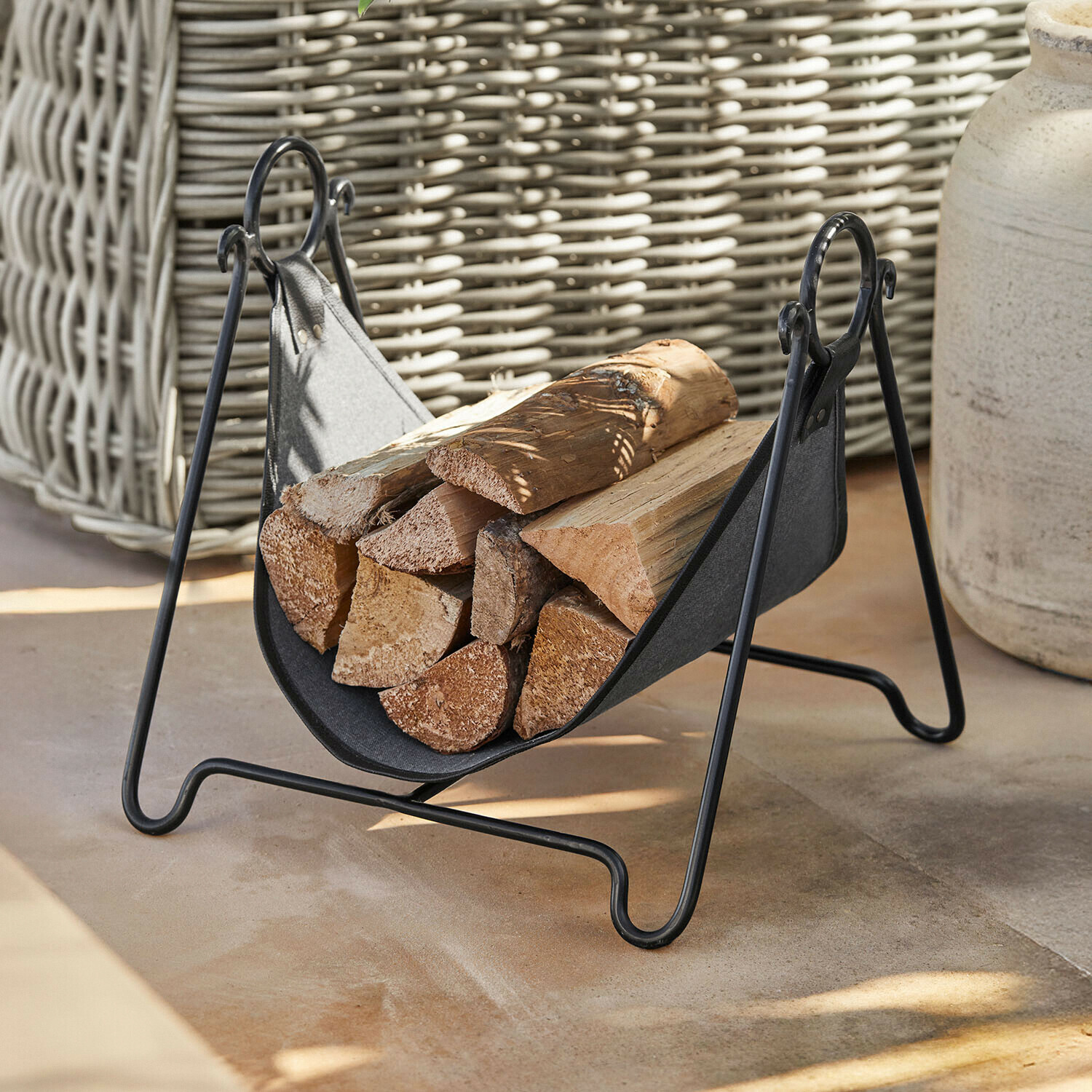 Soporte para leña de metal negro y tela con troncos, accesorio práctico para chimenea