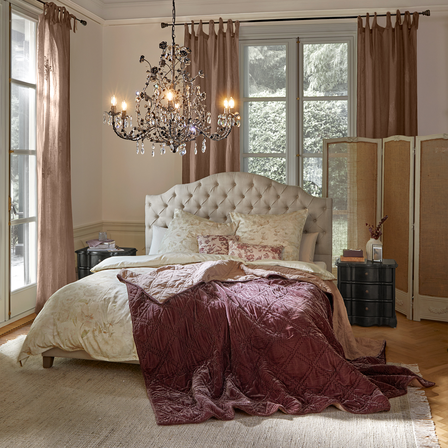 Dormitorio acogedor con cabecero beige acolchado y manta de terciopelo burdeos sobre la cama