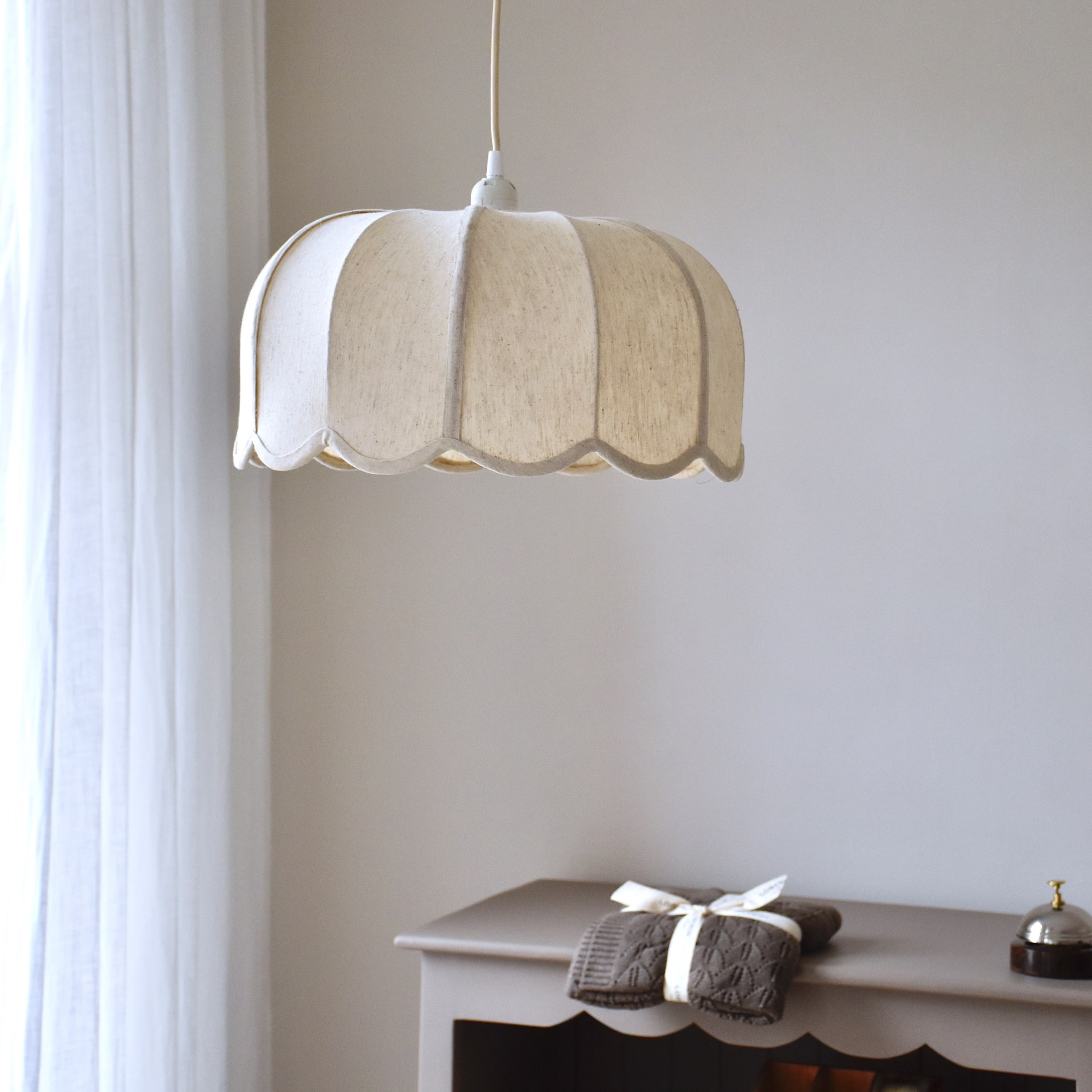 Lámpara colgante de tela color crema con diseño ondulado, iluminación suave para interiores