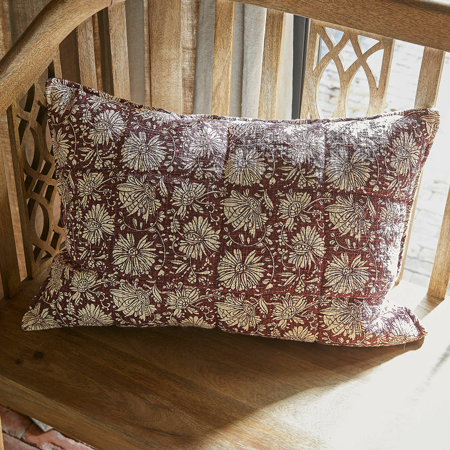 Funda de cojín Soleique Cojín decorativo rectangular de tela roja con diseño floral crema sobre silla de madera