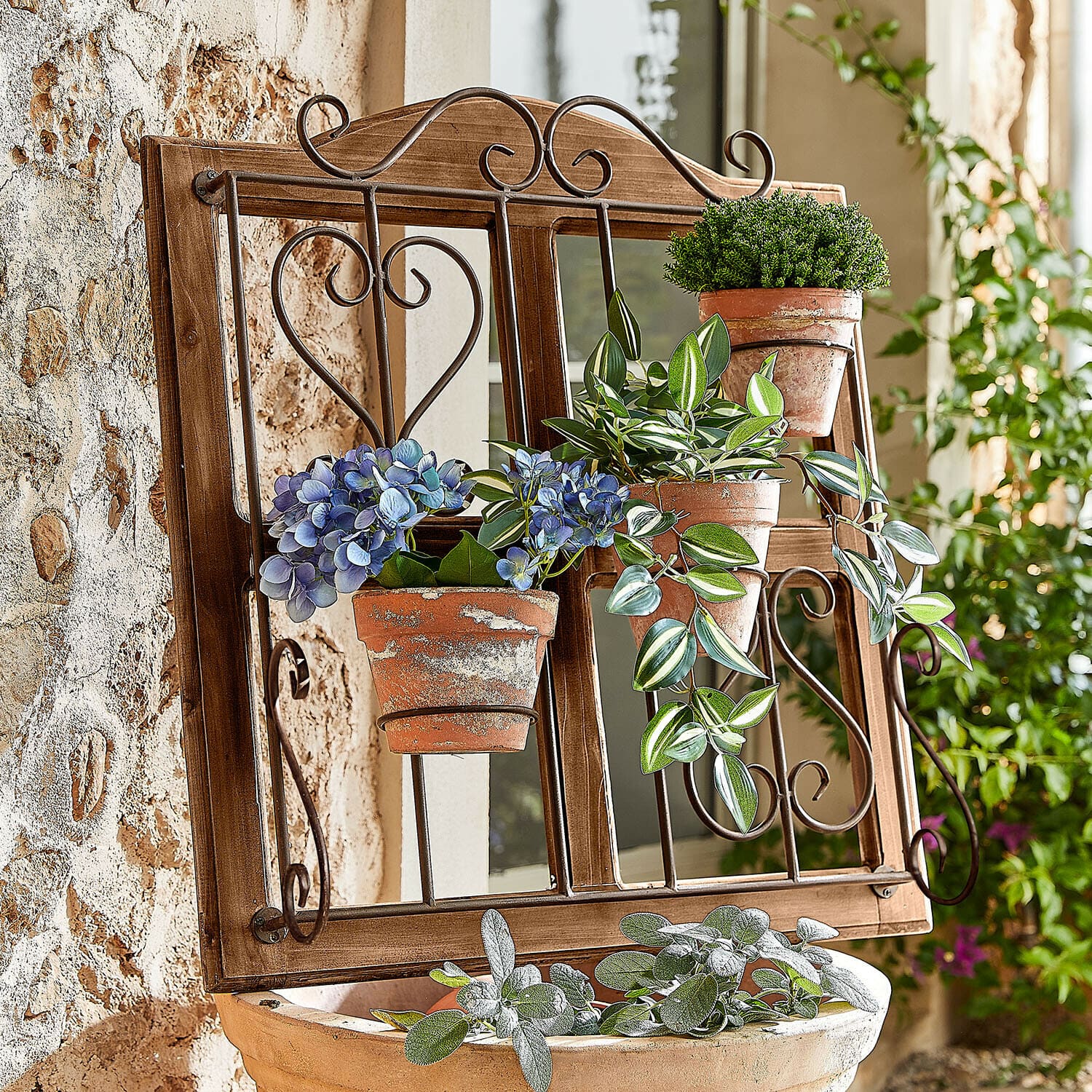 Soporte para macetas Nectarise Marco de madera con espejo y soportes metálicos para macetas con plantas verdes y flores azules estilo rústico