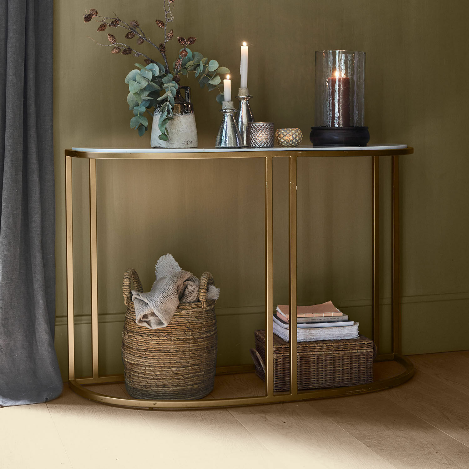 Consola Soréline Consola con tablero de mármol blanco y estructura metálica dorada, decorada con velas y jarrón con hojas verdes