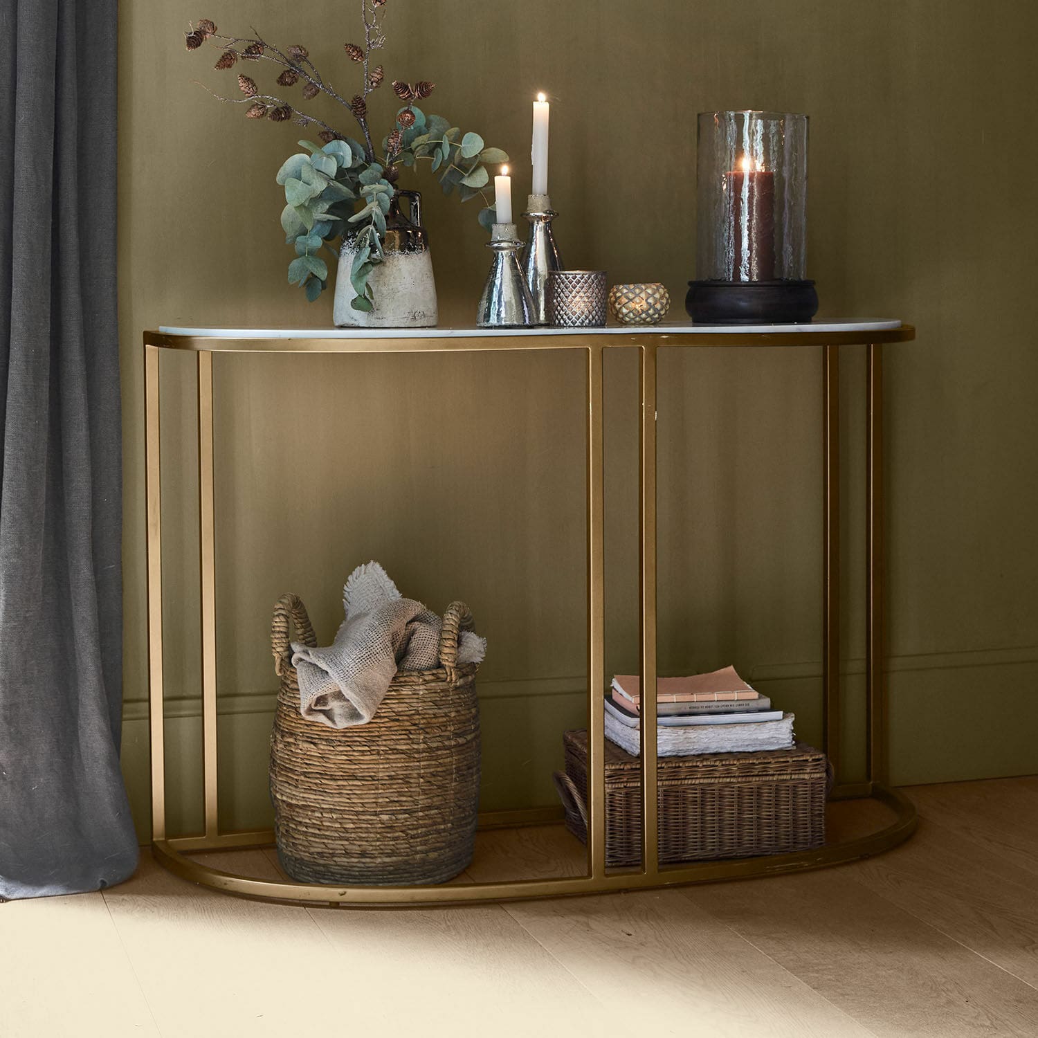 Consola Soréline Consola con tablero de mármol blanco y estructura metálica dorada, decorada con velas y jarrón con hojas verdes