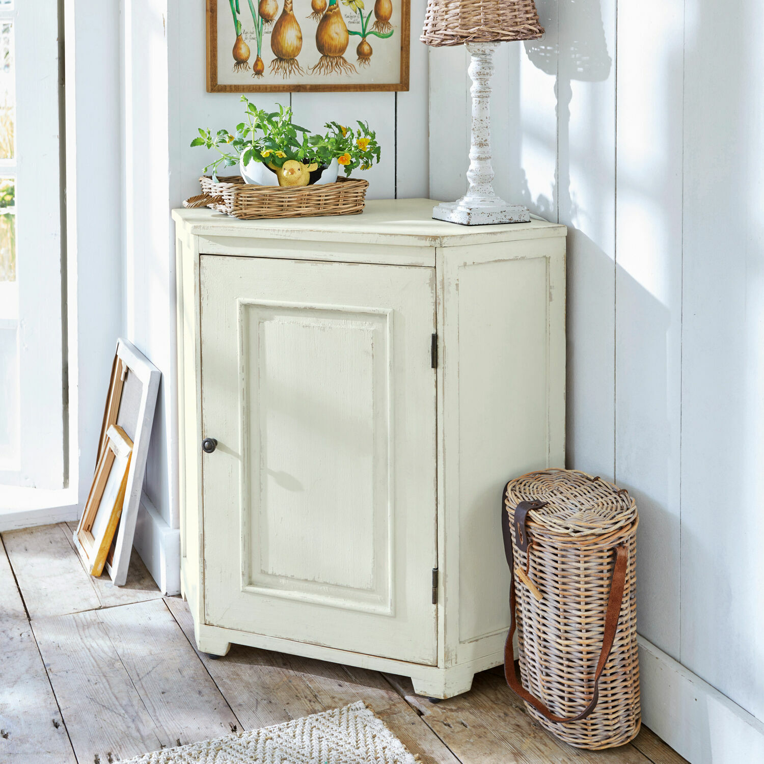 Cómoda esquinera Yurielka Aparador de madera crema con una puerta estilo vintage en habitación luminosa con cesta de mimbre