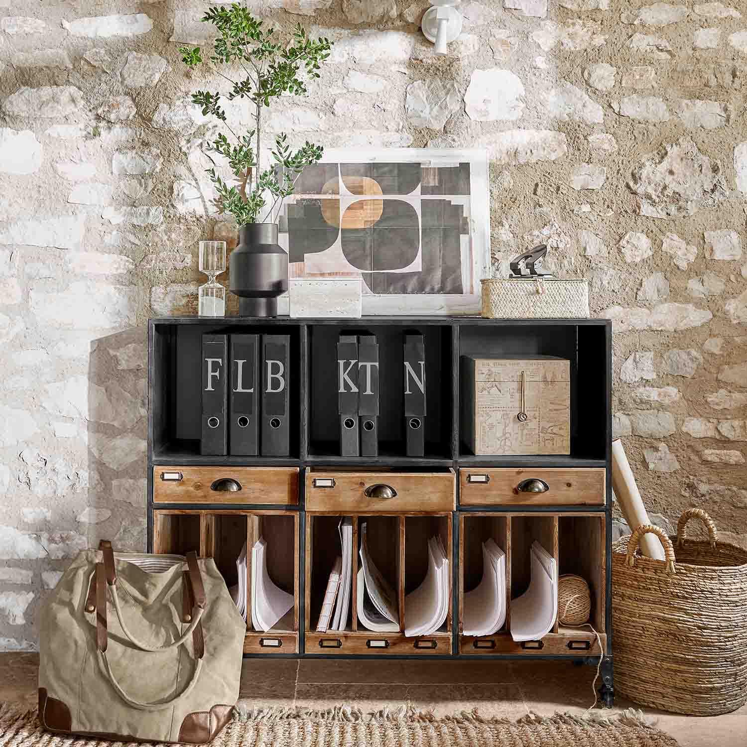 Aparador negro de metal y madera con cajones y archivadores frente a pared de piedra estilo loft