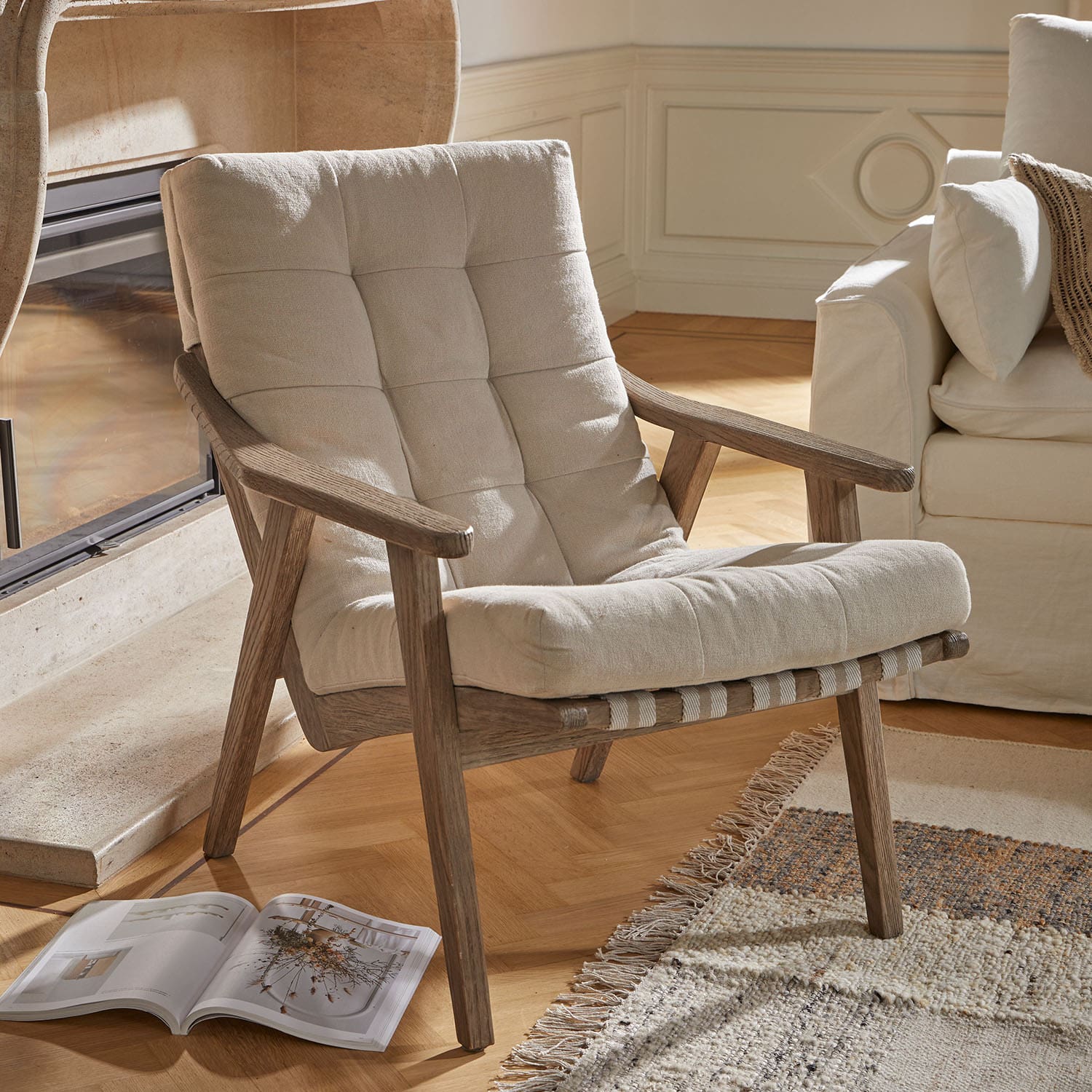 Sillón con tapizado beige claro y estructura de madera natural, ideal para salón acogedor