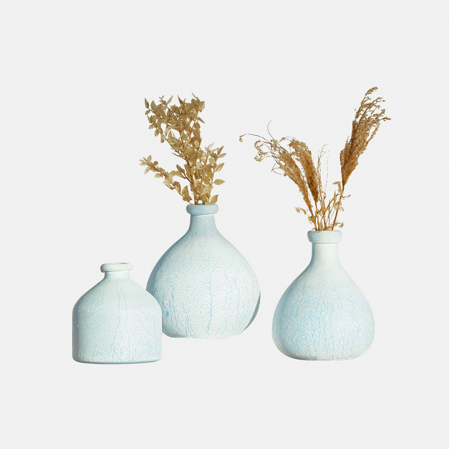 Set de 3 jarrones Donara Conjunto de tres jarrones de cerámica azul claro con plantas secas, decoración para el hogar