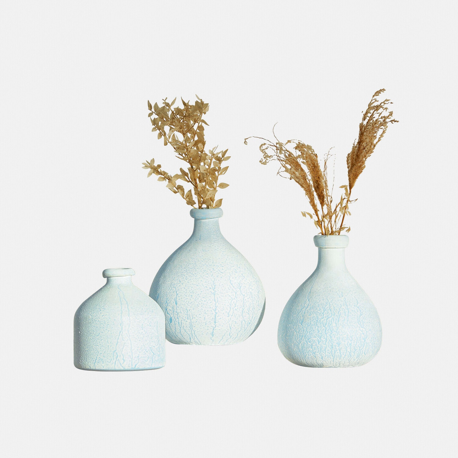 Set de 3 jarrones Donara Conjunto de tres jarrones de cerámica azul claro con plantas secas, decoración para el hogar