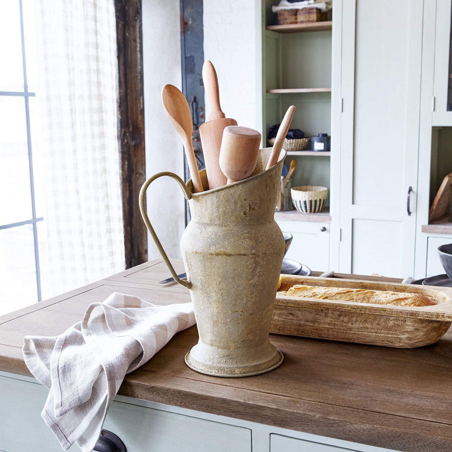 Jarra Asante Jarra metálica estilo vintage con utensilios de cocina de madera sobre encimera de madera