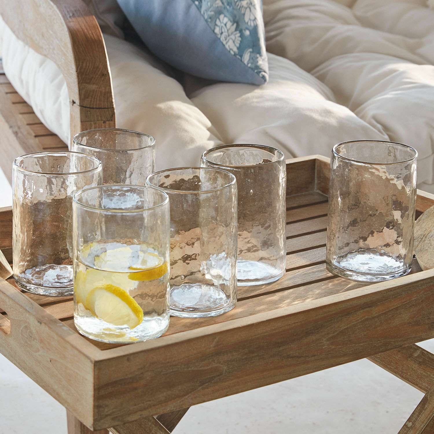 Set de 6 vasos Clarksville Conjunto de seis vasos transparentes con textura sobre bandeja de madera para servir bebidas