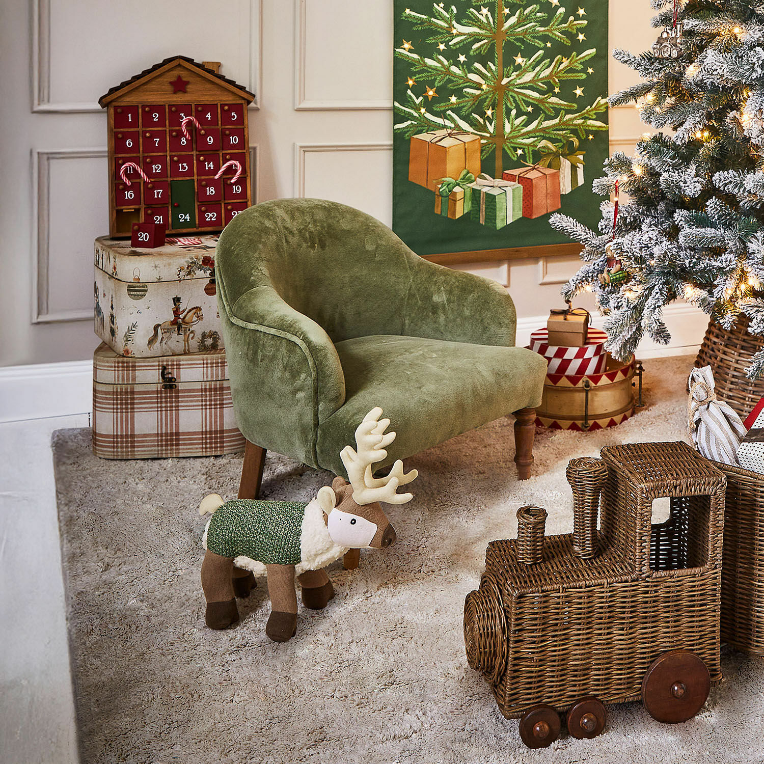 Sillón infantil Rowenna Sillón verde para niños con reno de peluche y tren de mimbre en habitación decorada para Navidad