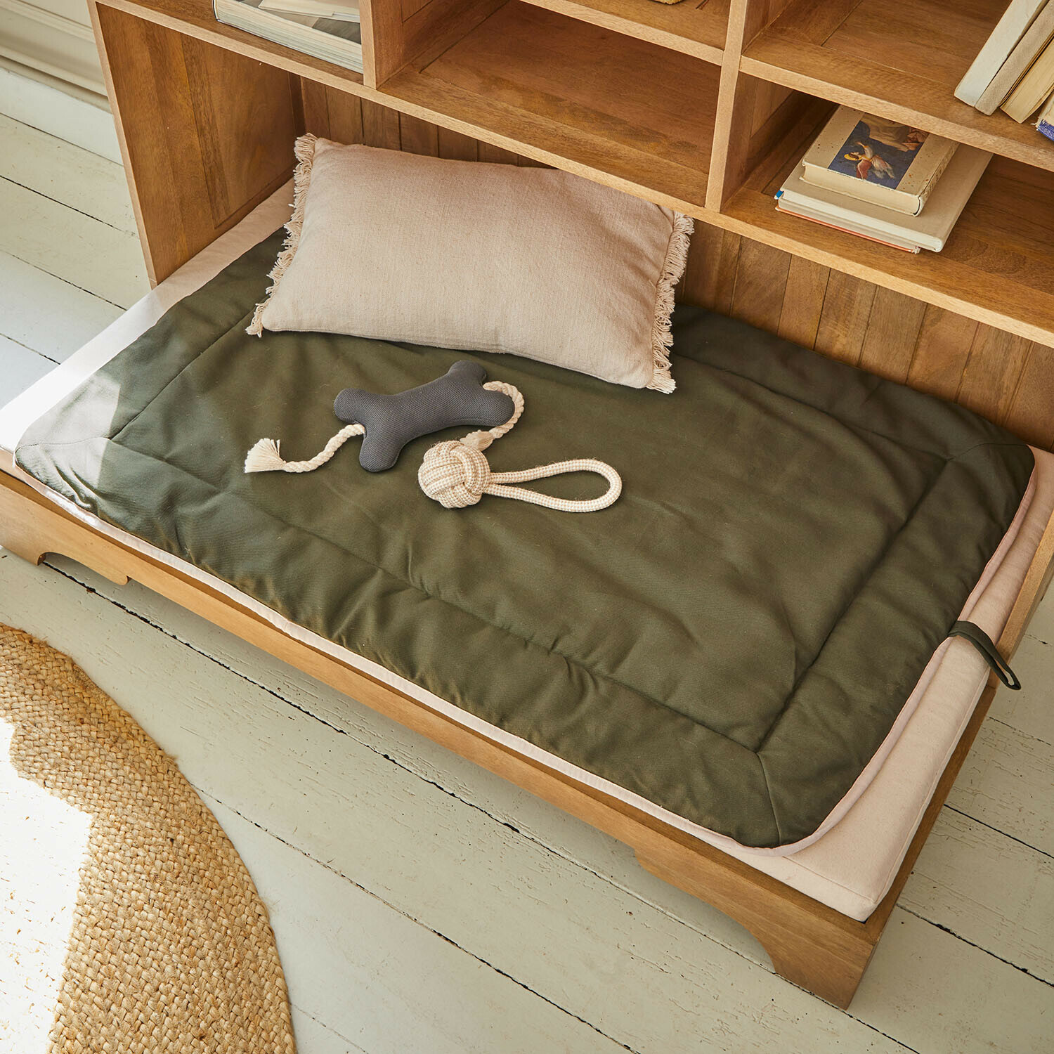 Alfombrilla para mascotas Dunelyn Alfombrilla verde y cojín beige de tela en cama de madera para perro con juguetes para morder