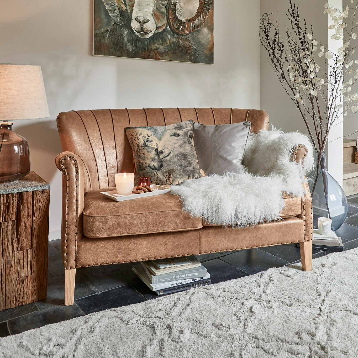Sofá Brookfield Sofá marrón de material suave con cojines decorativos y manta blanca de piel sintética en sala de estar