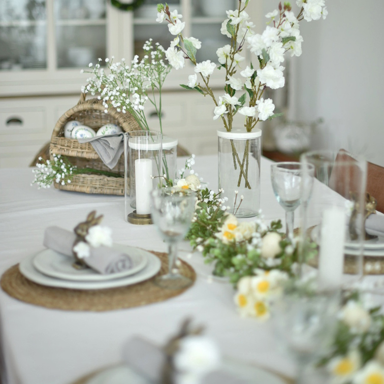 Mesa elegantemente decorada con flores blancas y velas para una fiesta primaveral