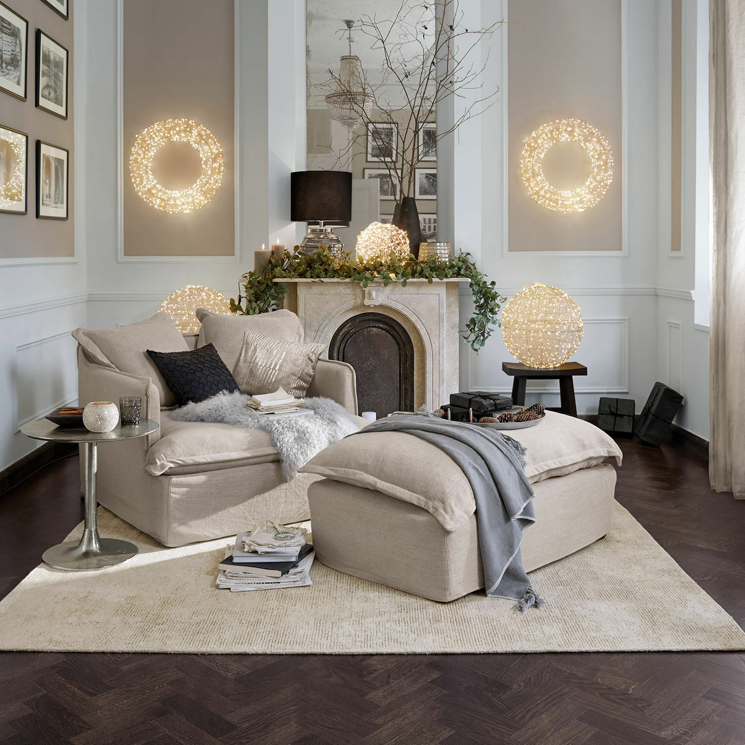 Sillón y reposapiés beige de tela en sala con iluminación LED decorativa y chimenea