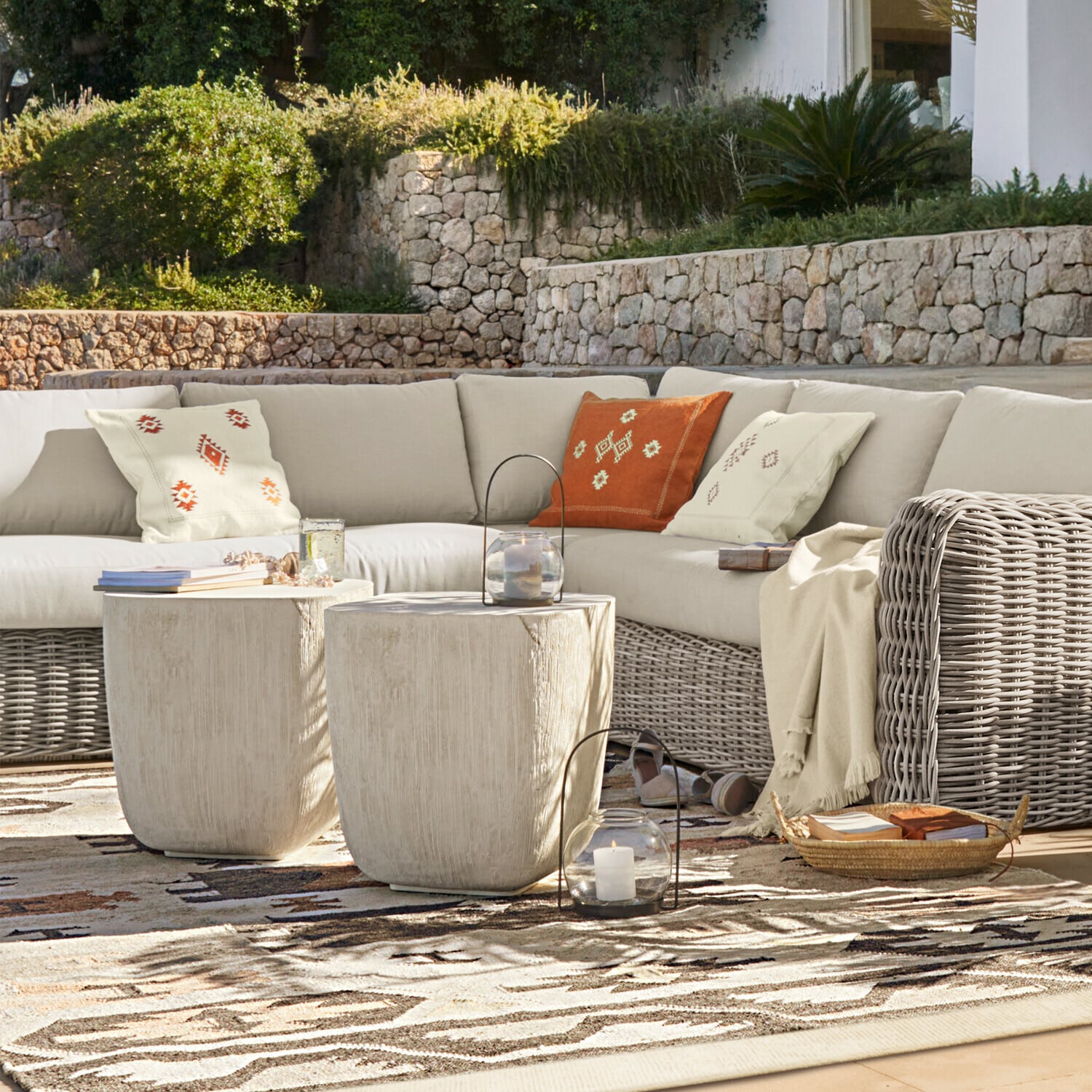 Sillón esquinero Eravinto Conjunto de muebles de exterior con sofá de ratán beige y dos mesas auxiliares claras en terraza