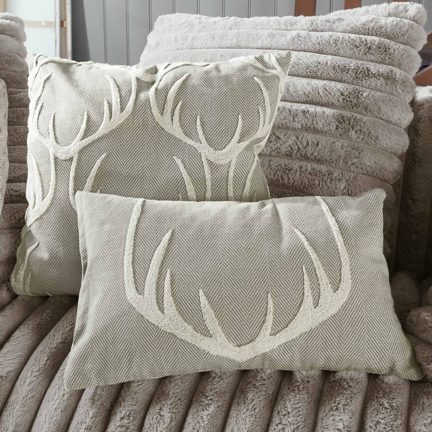 Cojines beige con diseño de astas sobre tela suave, textiles decorativos para salón acogedor