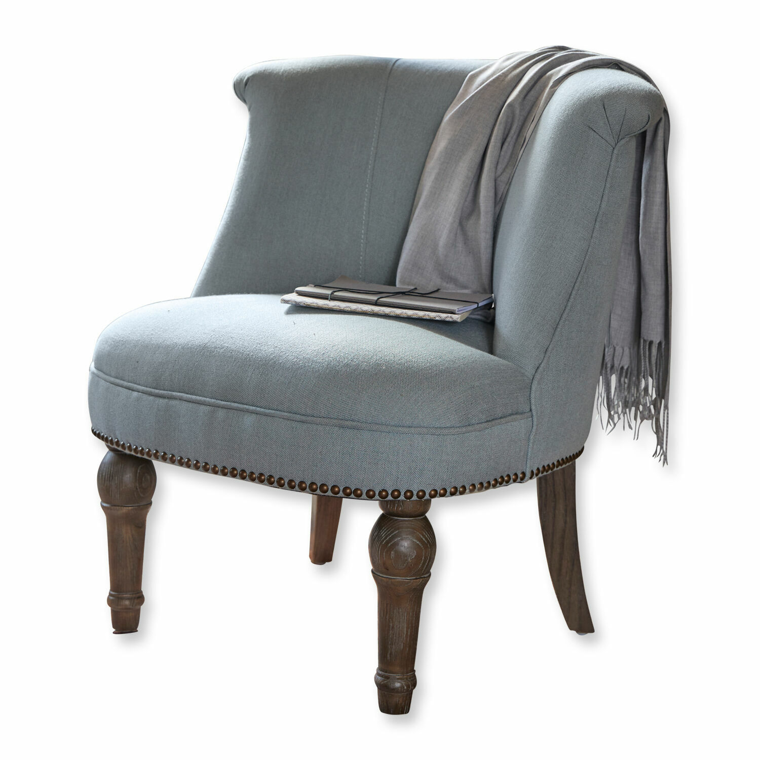 Sillón Francet Sillón tapizado gris con patas de madera tallada y clavos decorativos, con bufanda y cuadernos