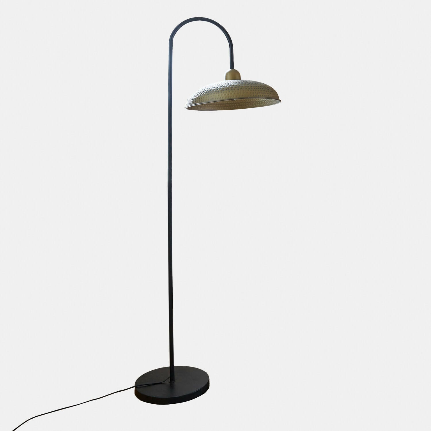 Lámpara de pie con pantalla metálica martillada en color latón y base negra para decoración interior