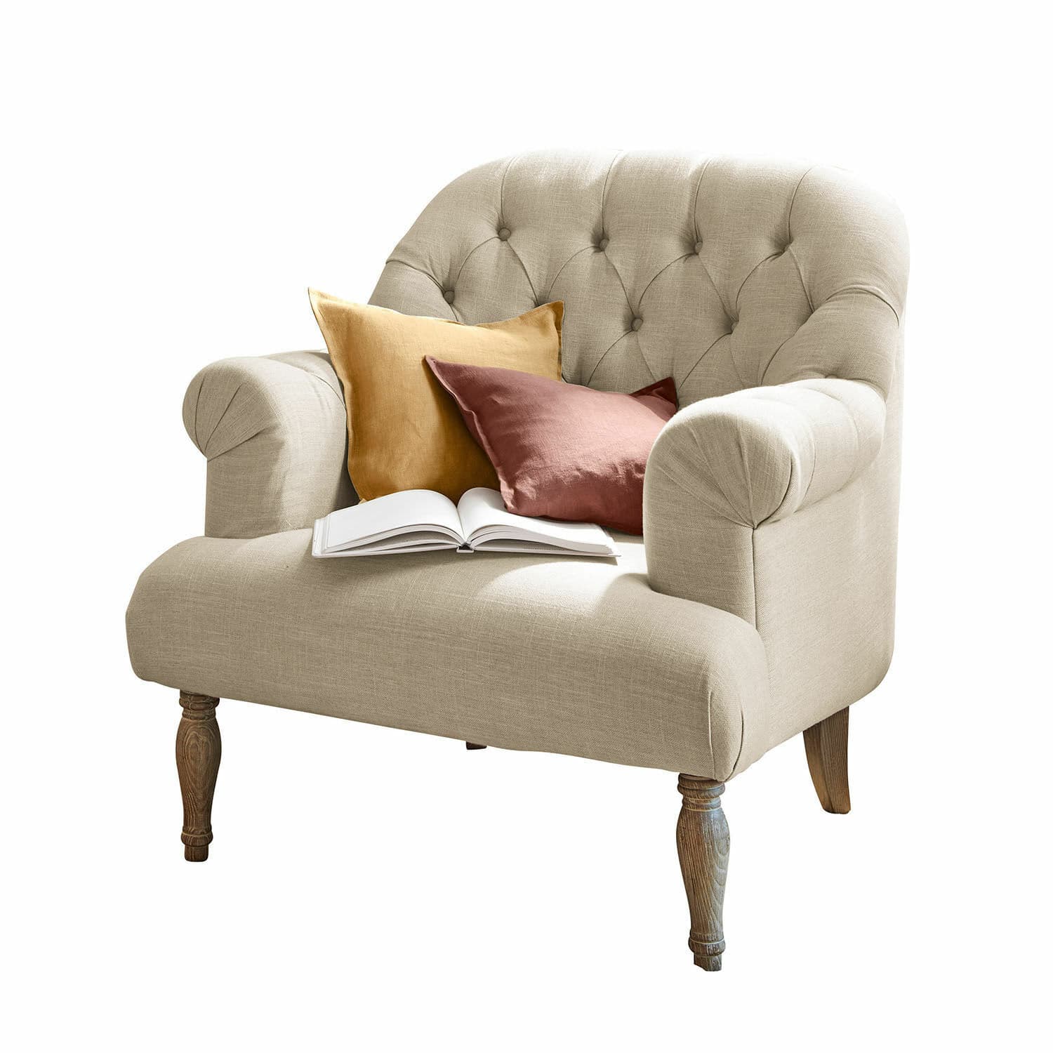 Sillón Shambrook Sofá beige tapizado con patas de madera, cojines de colores y libro abierto para sala acogedora