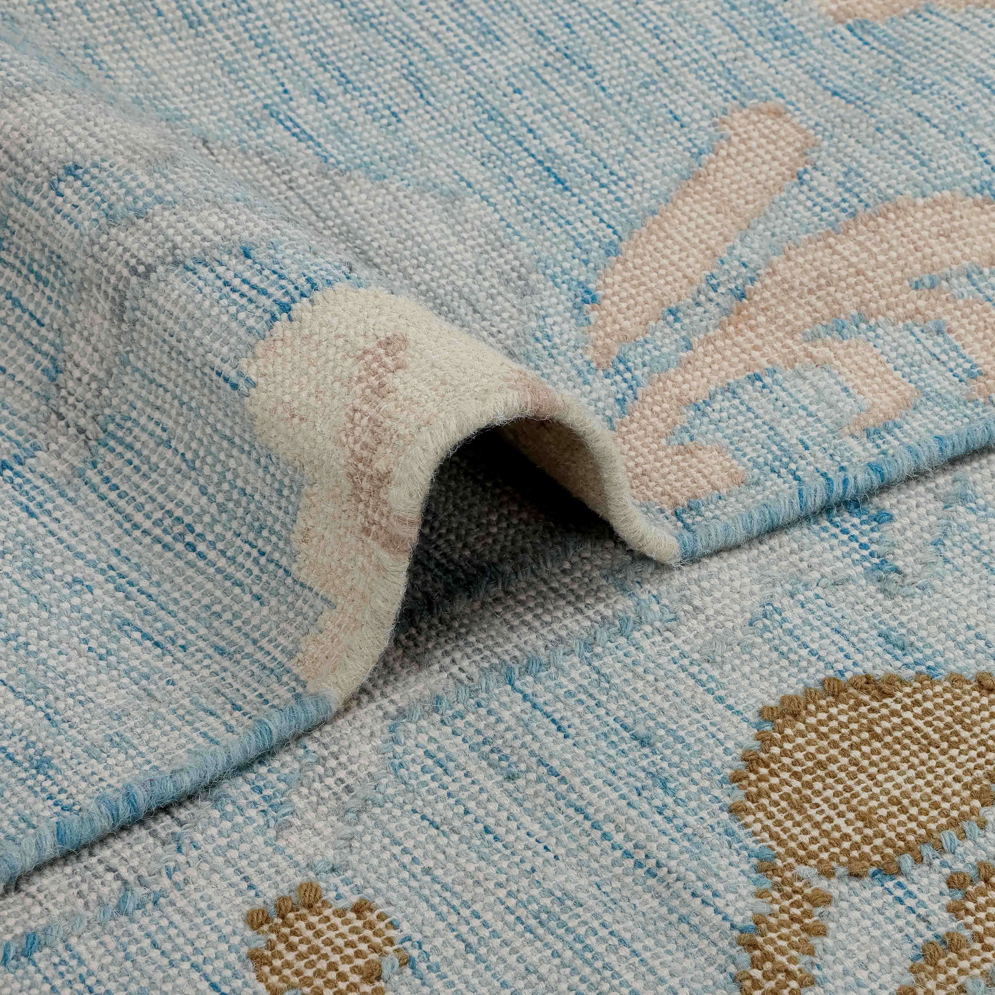Alfombra de tejido suave en tonos azul y beige con diseño sutil, decoración para el hogar