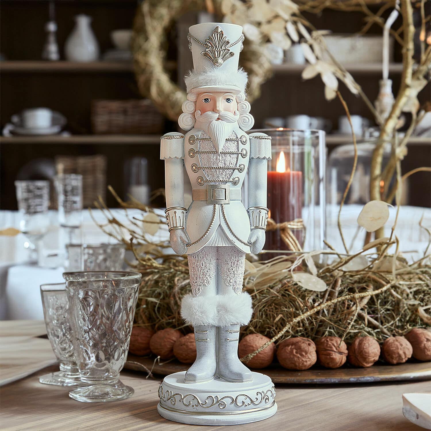 Cascanueces de madera blanco con detalles de piel y adornos plateados sobre mesa navideña