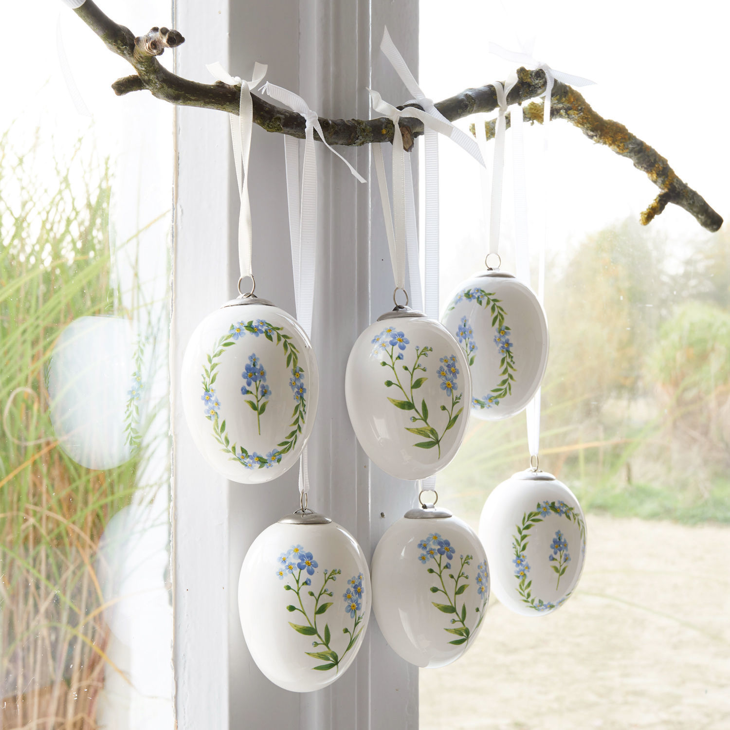 Set de 6 huevos de Pascua Fierolla Huevos de cerámica blanca con flores azules colgados de una rama, decoración primaveral