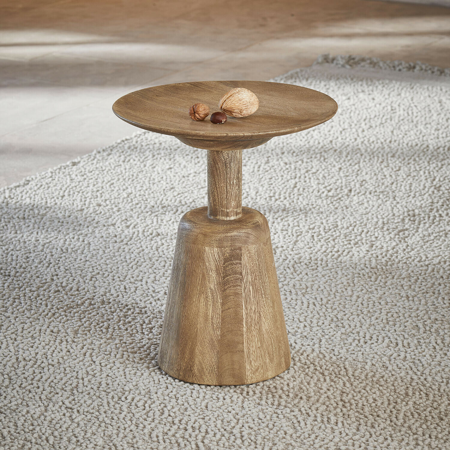Mesa auxiliar Ulric Mesa auxiliar de madera en color natural sobre alfombra clara, diseño minimalista para salón