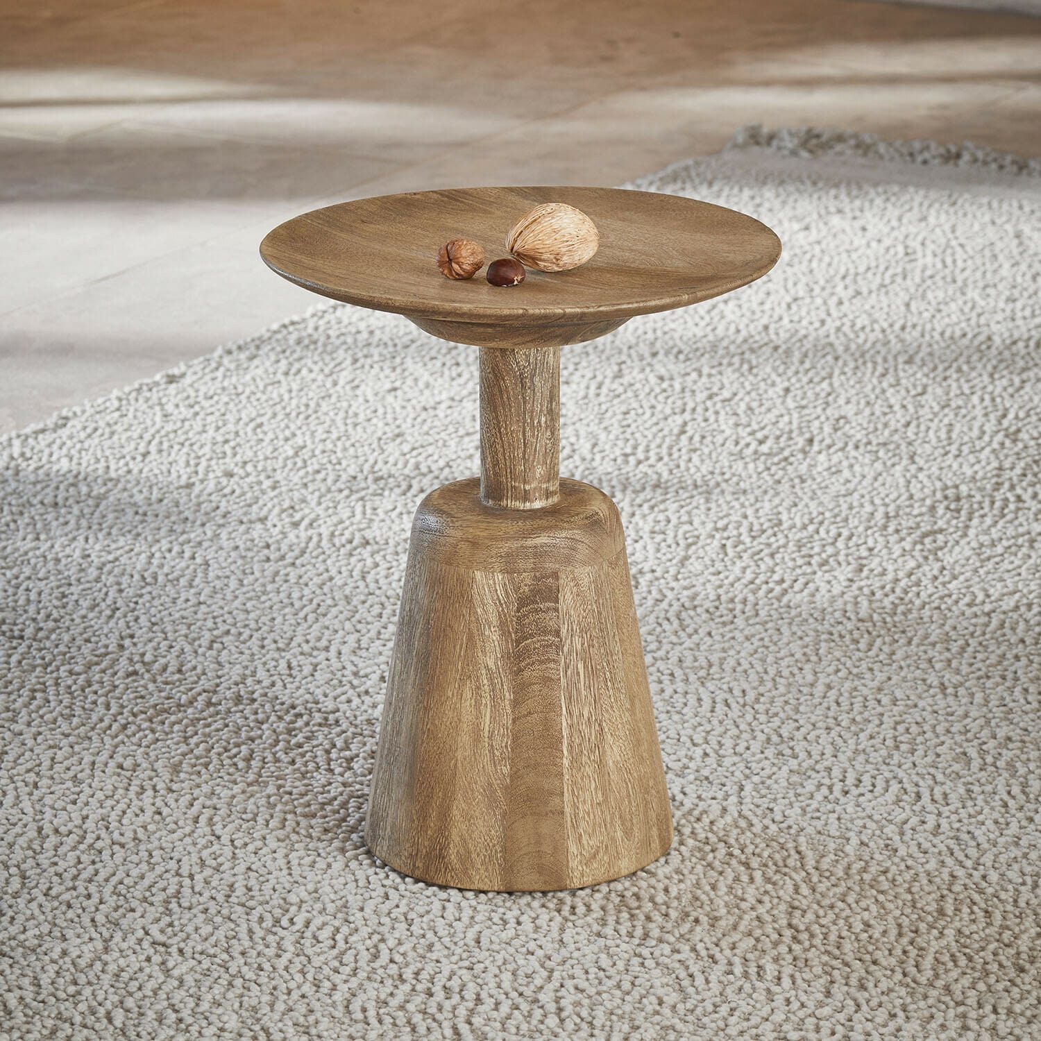 Mesa auxiliar Ulric Mesa auxiliar de madera en color natural sobre alfombra clara, diseño minimalista para salón