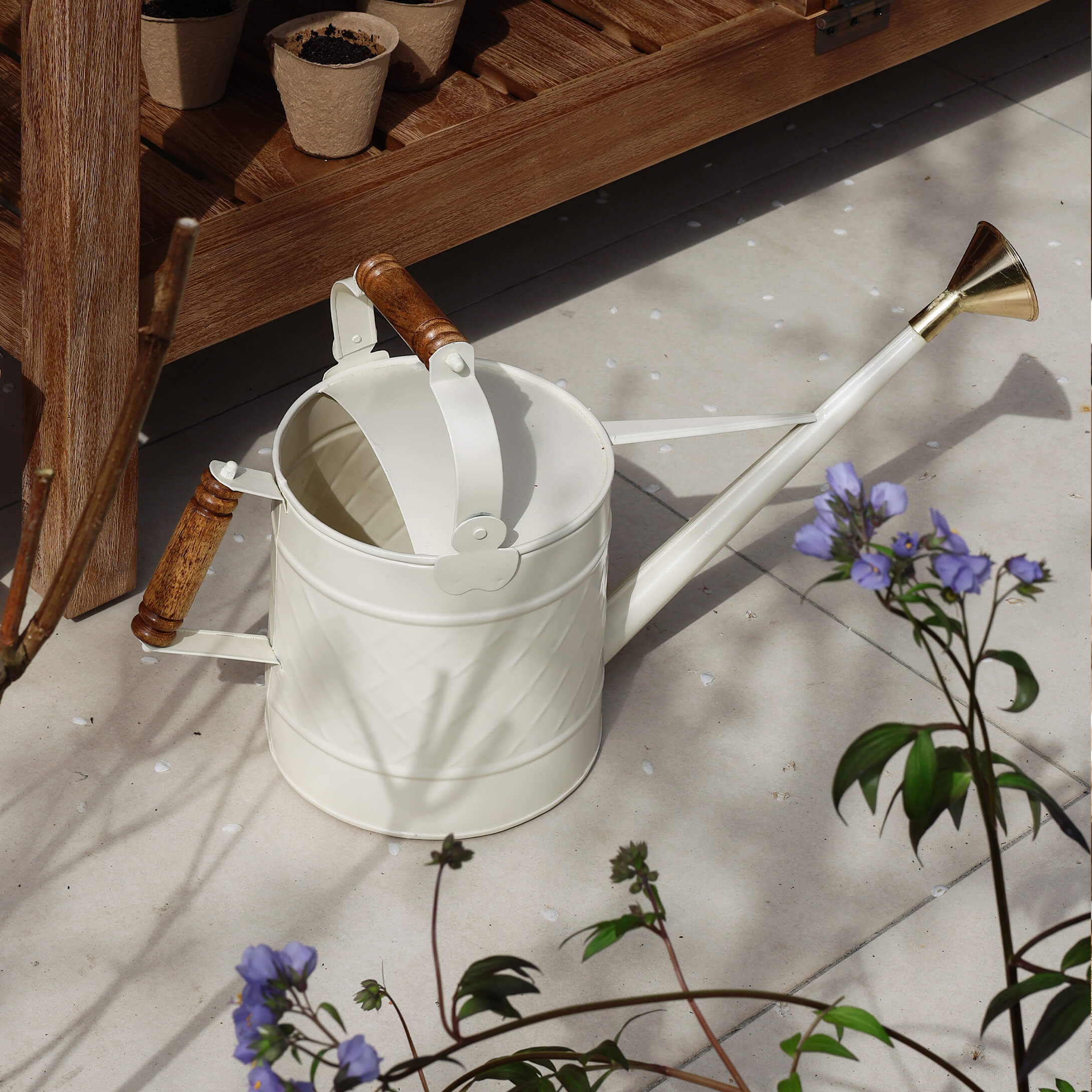 Regadera metálica blanca con asas de madera y pico de latón para jardinería