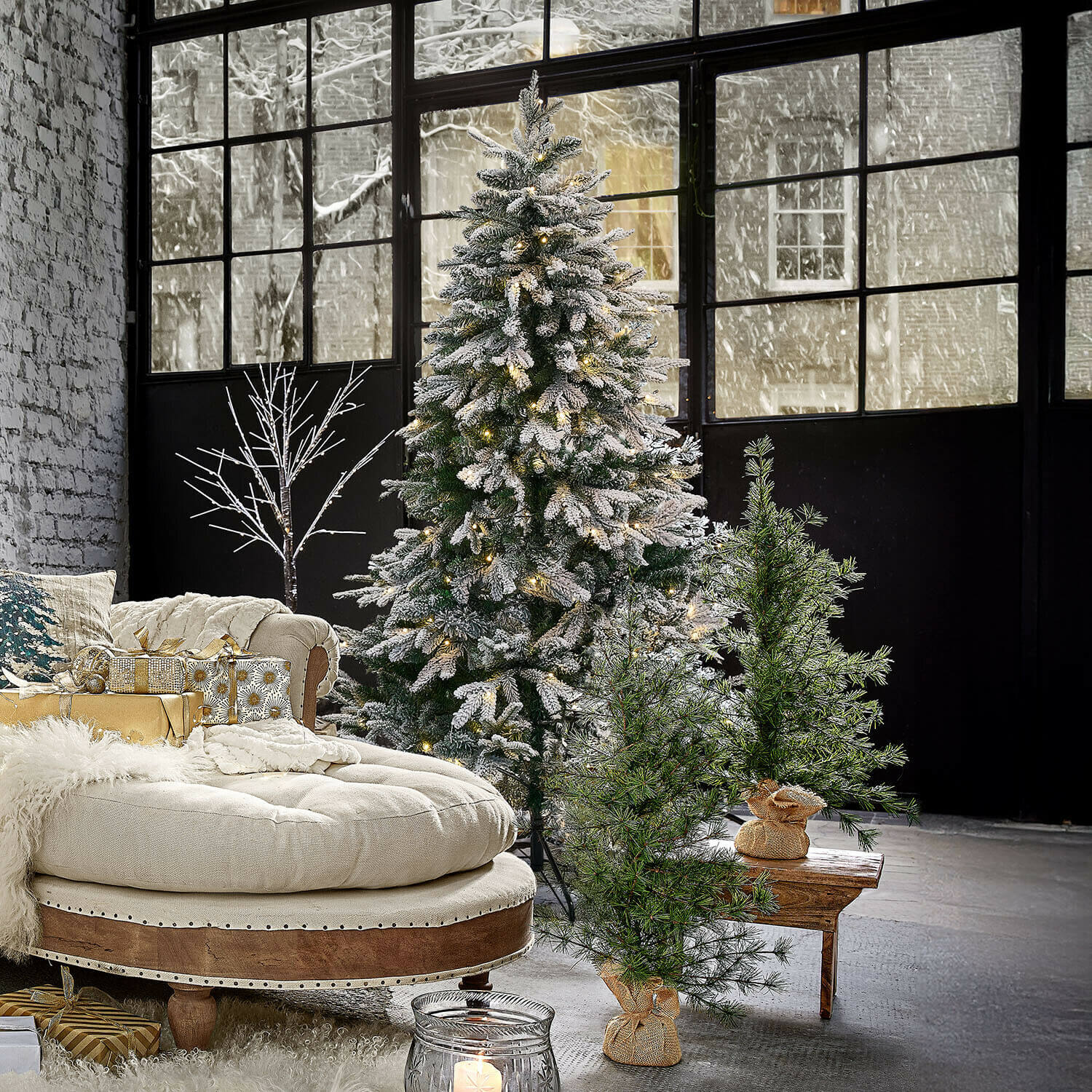 Árbol de Navidad Norila Árbol de Navidad artificial con nieve y luces en salón moderno con sofá beige y regalos dorados