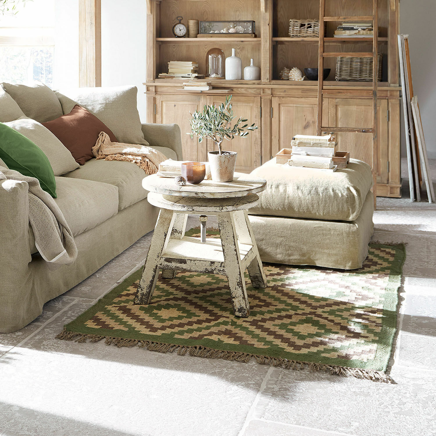 Alfombra Dailies Sala acogedora con sofá beige, mesa de madera envejecida y alfombra verde y marrón estilo vintage