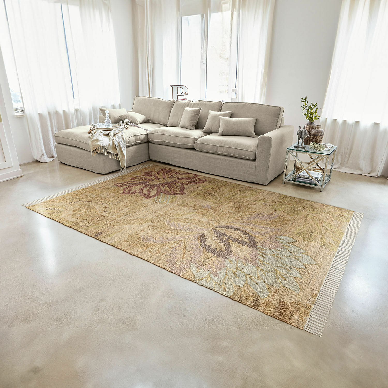 Alfombra Willeque Alfombra beige con diseño floral sobre suelo claro en sala moderna con sofá beige