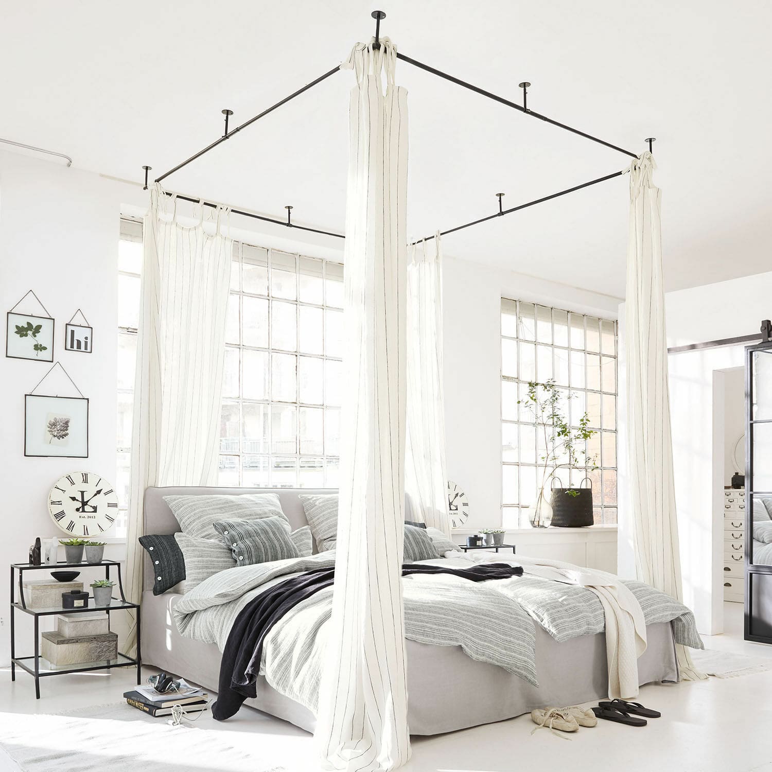 Dosel de cama Giroux Cama con dosel moderna de tela gris claro y cortinas blancas en dormitorio luminoso con grandes ventanas