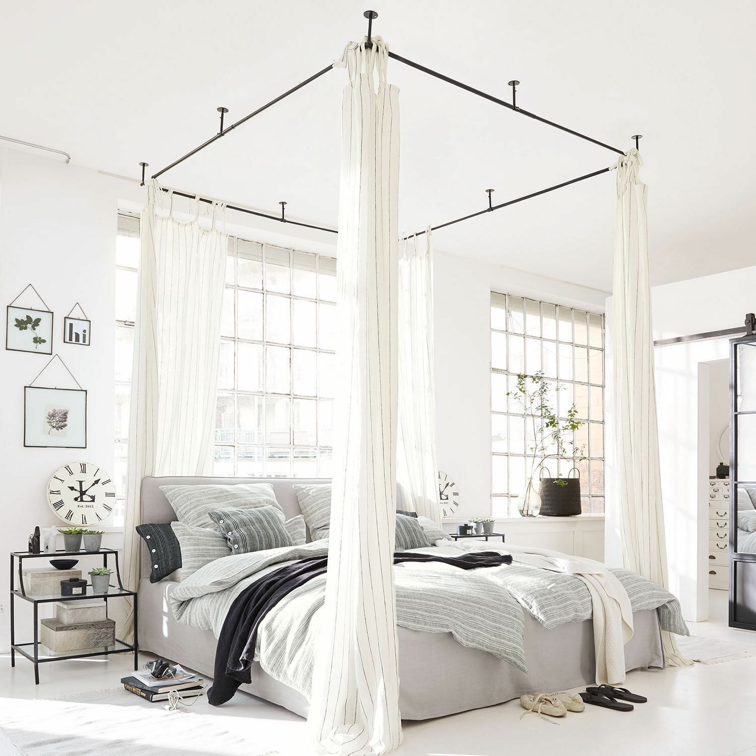 Dosel de cama Giroux Cama con dosel moderna de tela gris claro y cortinas blancas en dormitorio luminoso con grandes ventanas