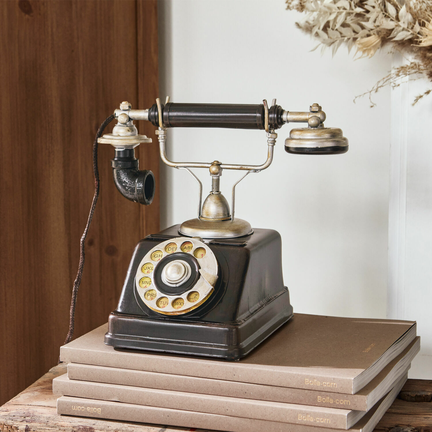 Teléfono decorativo Upavon Teléfono negro antiguo con disco giratorio y partes metálicas sobre pila de libros marrones