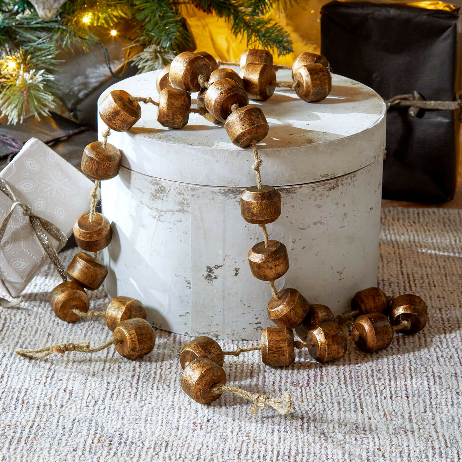 Guirnalda Caralinas Guirnalda decorativa de cuentas de madera marrón sobre fondo claro, adorno navideño