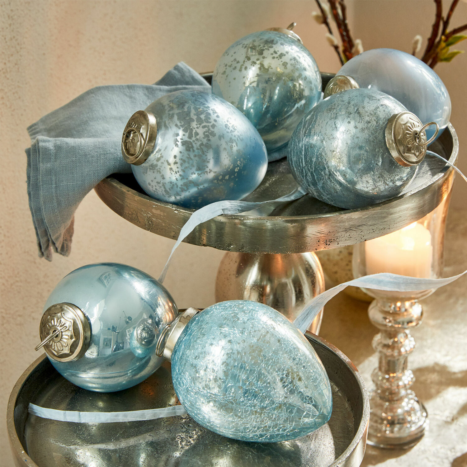 Set de 6 huevos de Pascua Cataleya Conjunto de bolas navideñas de vidrio azul con colgantes metálicos sobre bandeja decorativa plateada