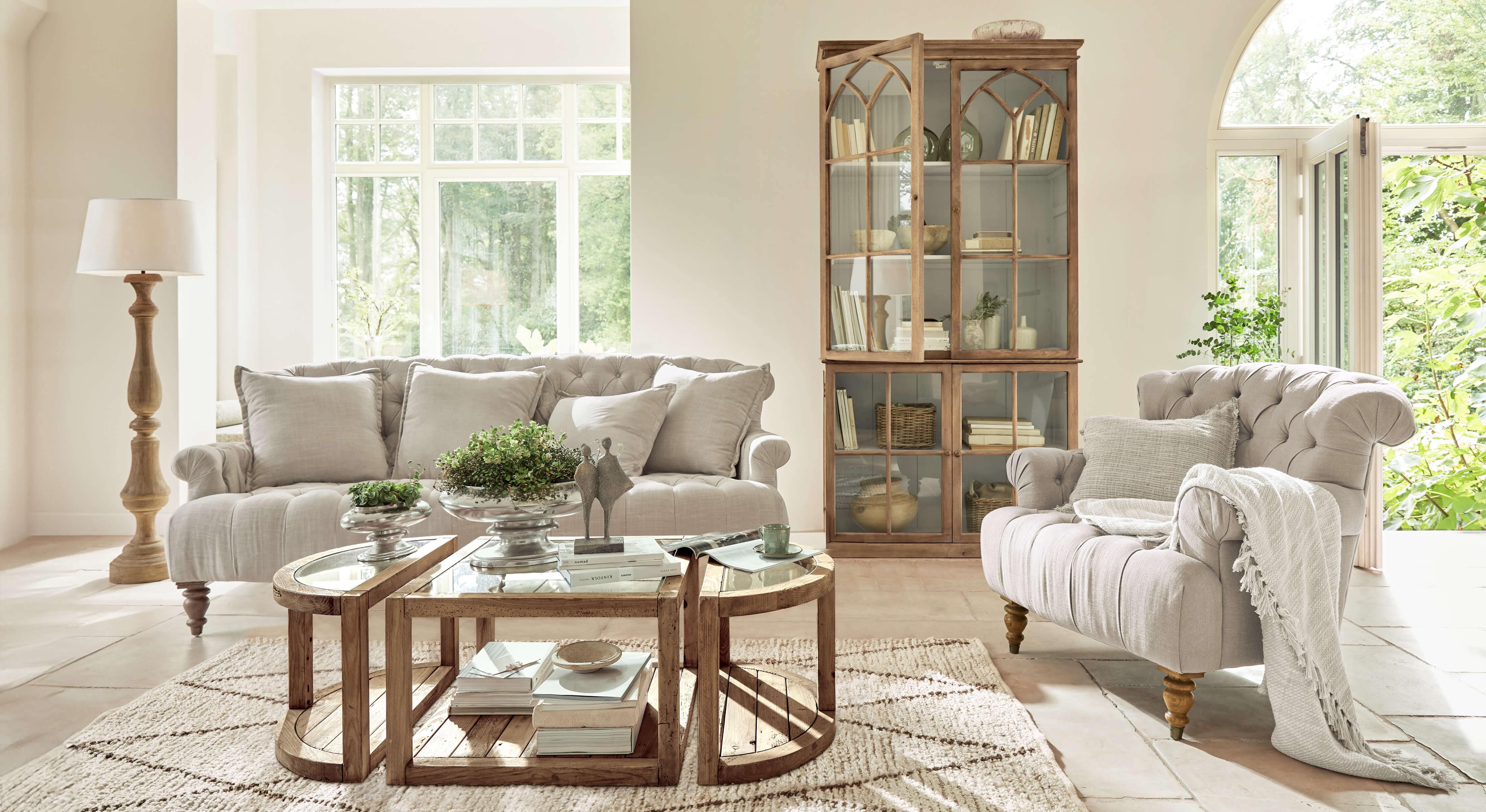 Salón acogedor con sofá y sillón beige de tela, muebles de madera y mesa de centro rústica