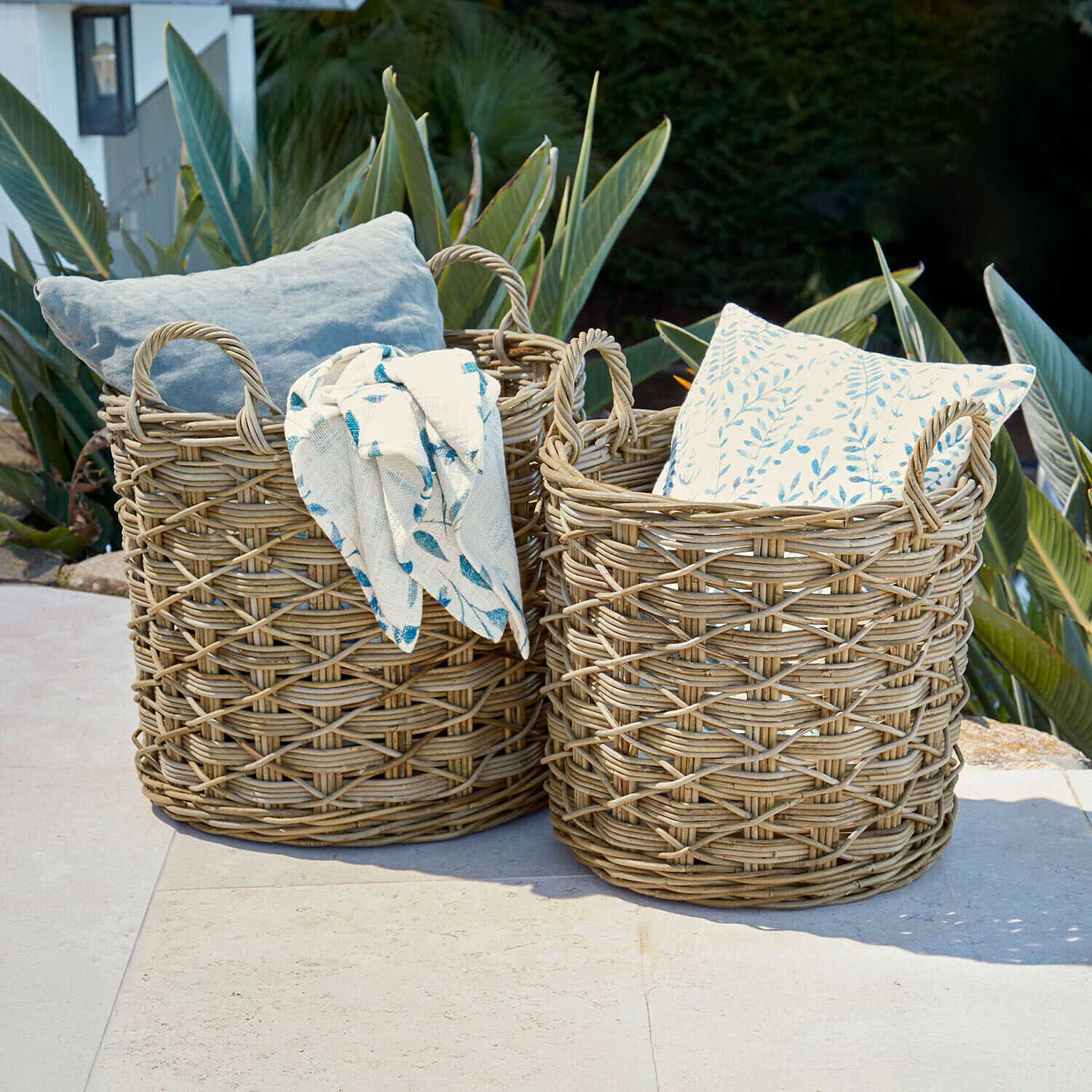 Dos cestas de mimbre natural con cojines y manta, decoración exterior para jardín