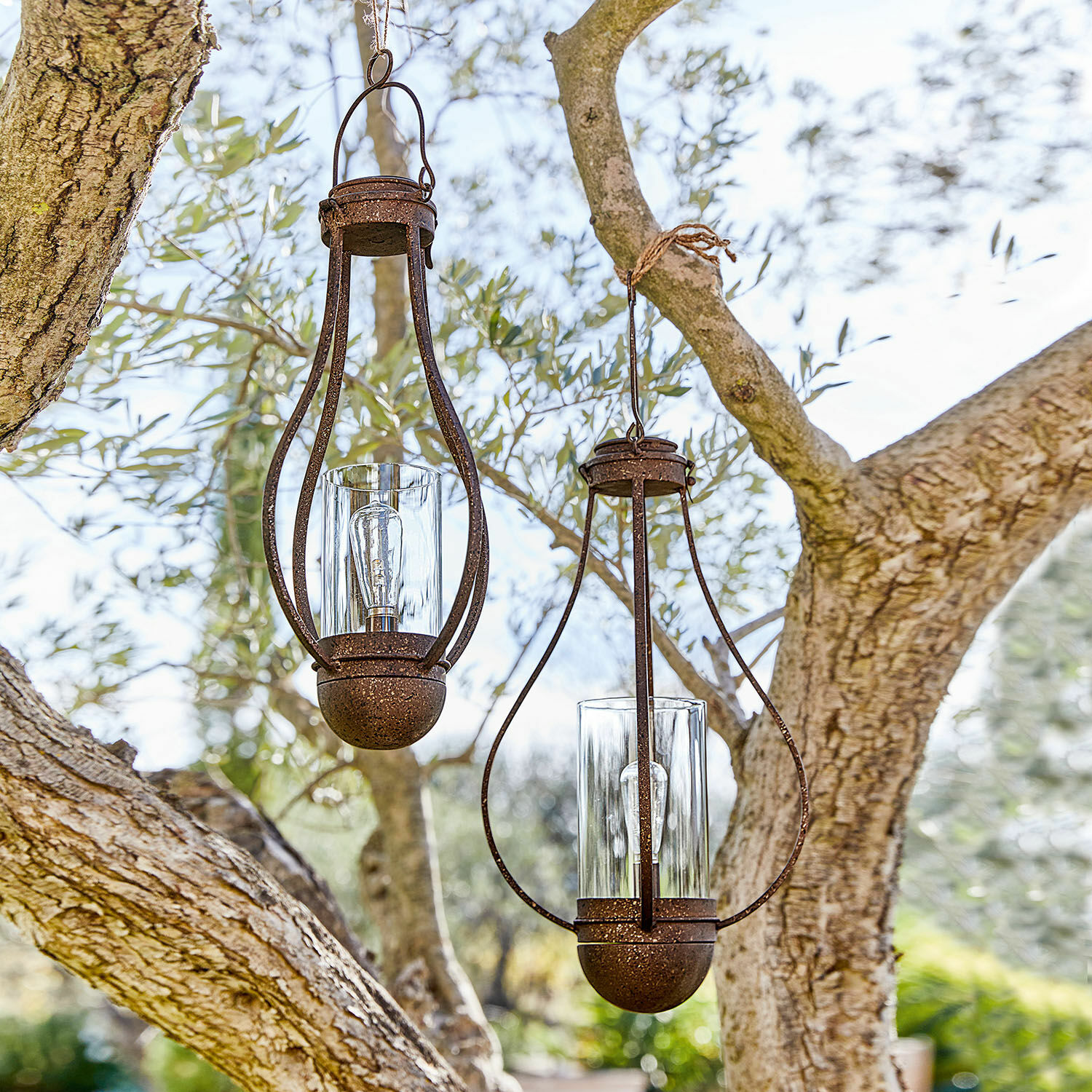 Set de 2 faroles solares colgantes Marsa Dos faroles colgantes de metal oxidado con vidrio transparente en un jardín exterior
