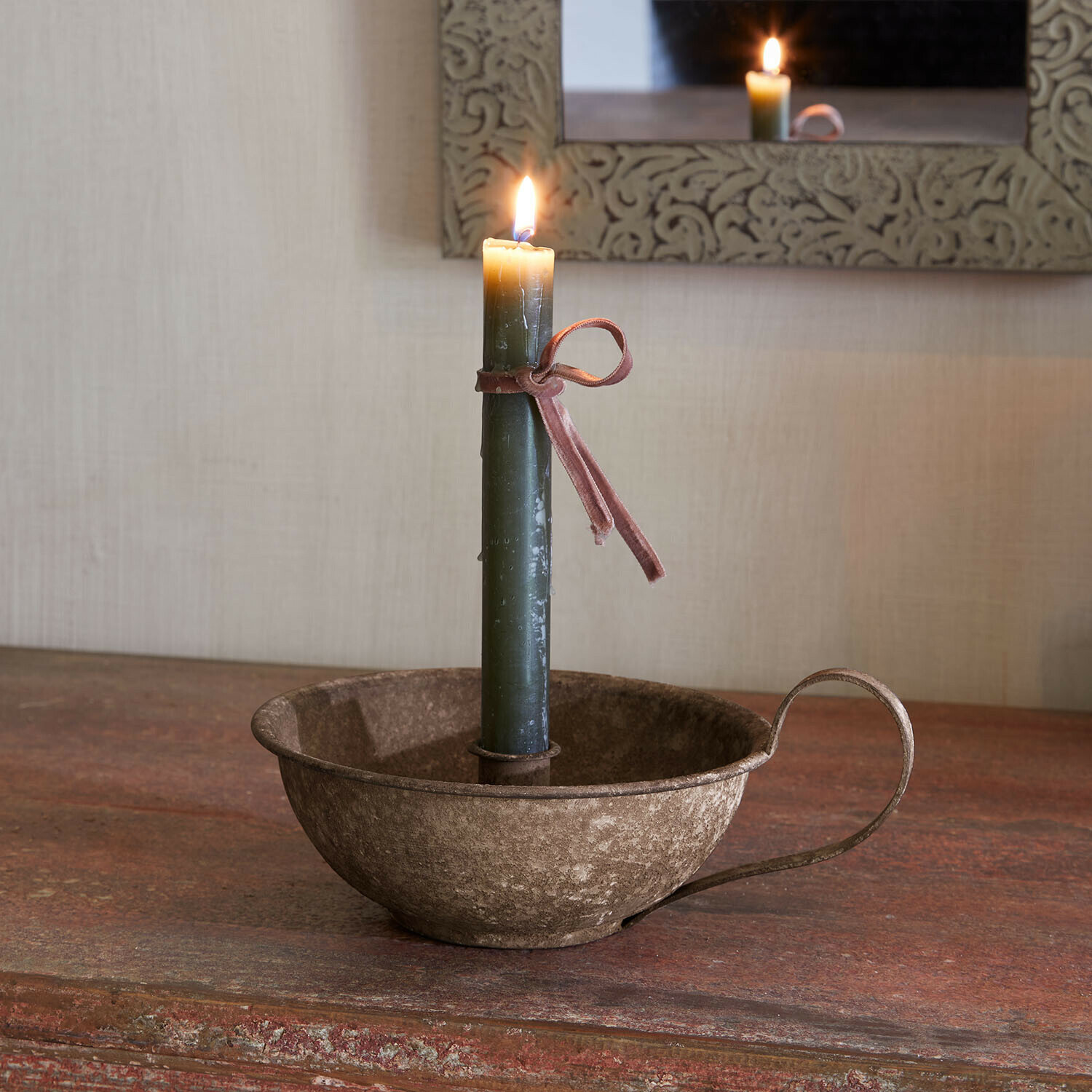 Candelero Drélovine Vela verde con lazo rosa en candelabro metálico rústico sobre mesa de madera