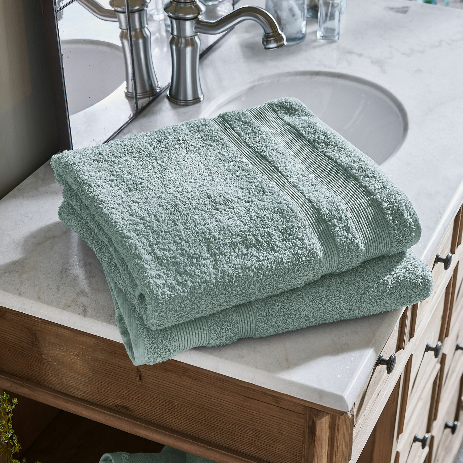 Set de 2 toallas de baño Bourogne Toallas verdes de algodón suave sobre lavabo de mármol con mueble de madera en baño