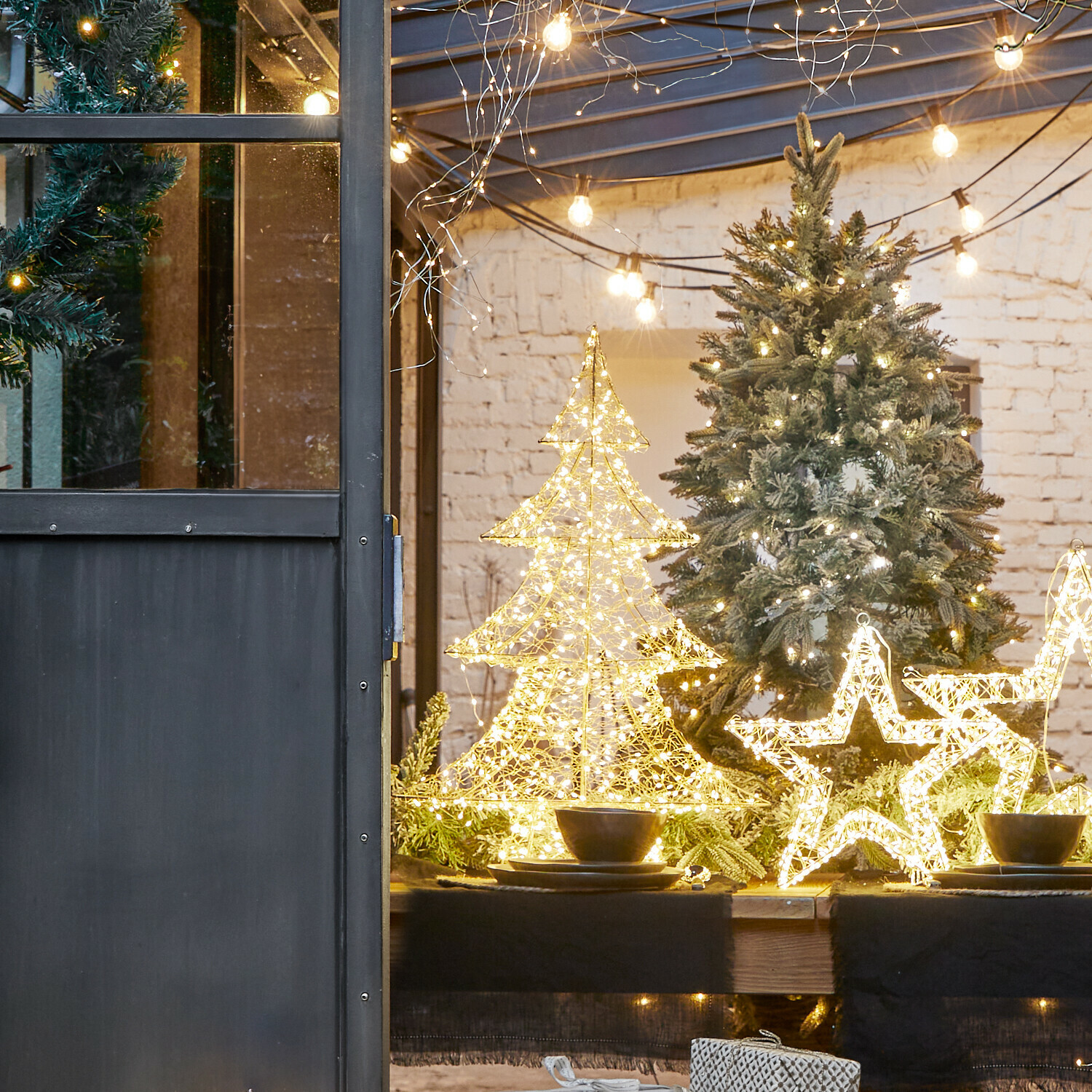 Árbol LED Vivetelle Decoraciones navideñas LED en forma de árbol y estrella sobre mesa de madera con ramas verdes