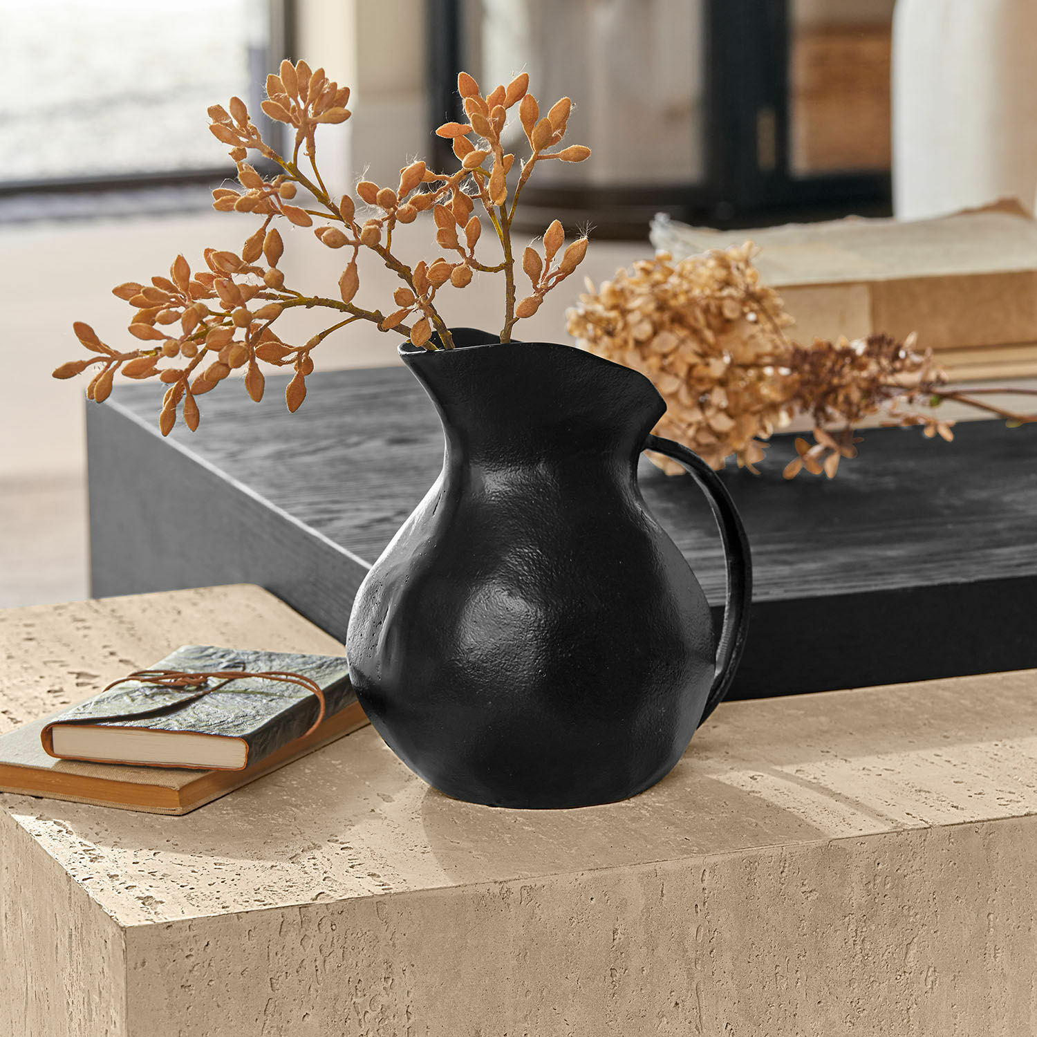 Jarrón Évignac Jarra de cerámica negra con flores secas sobre mesa de piedra, decoración interior