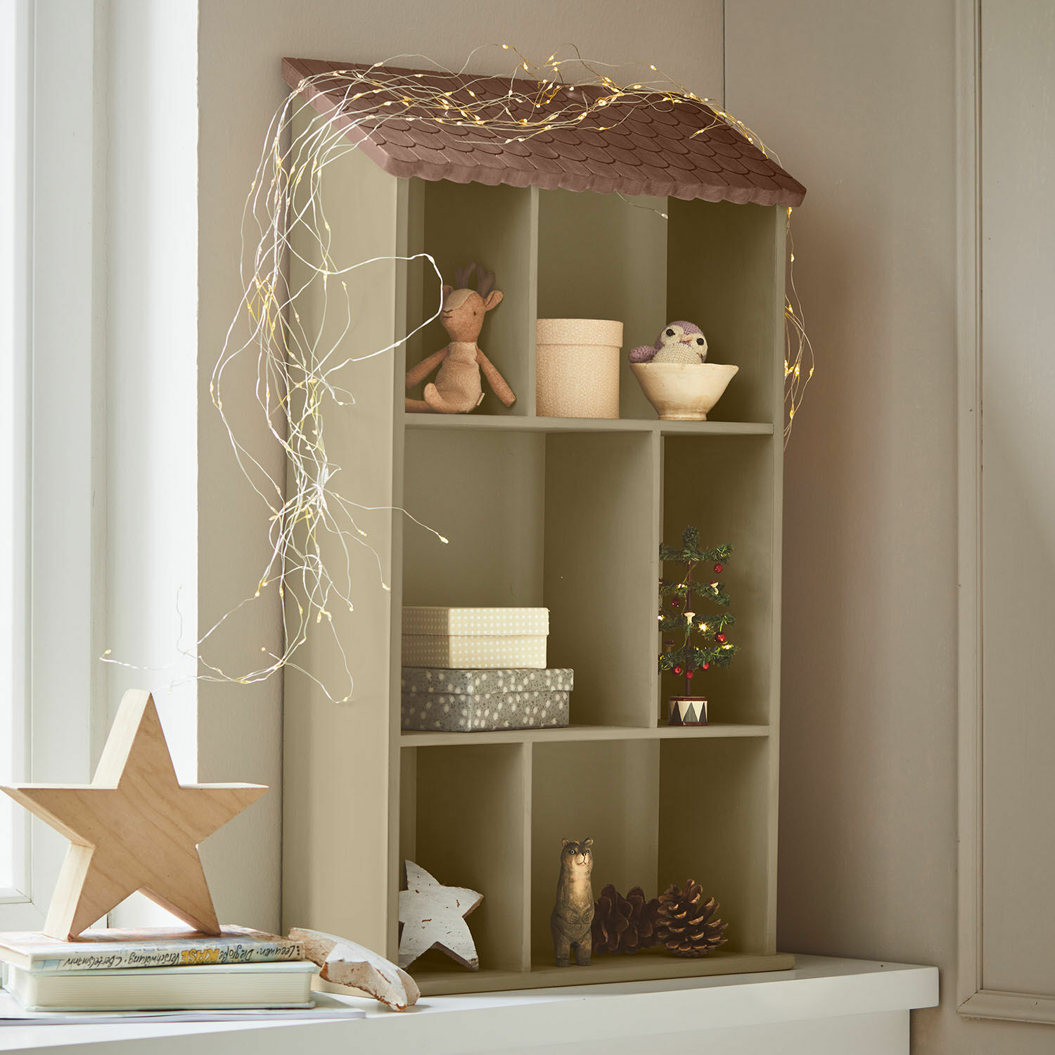 Estante de pared Zerith Estantería de madera en forma de casa color oliva con decoración navideña y luces LED
